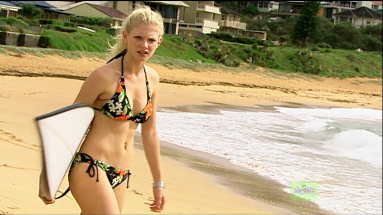 Mit ihre schlanke Körper und Mittlblond Haartyp ohne BH (BH-Größe 34B) auf Strand im Bikini
